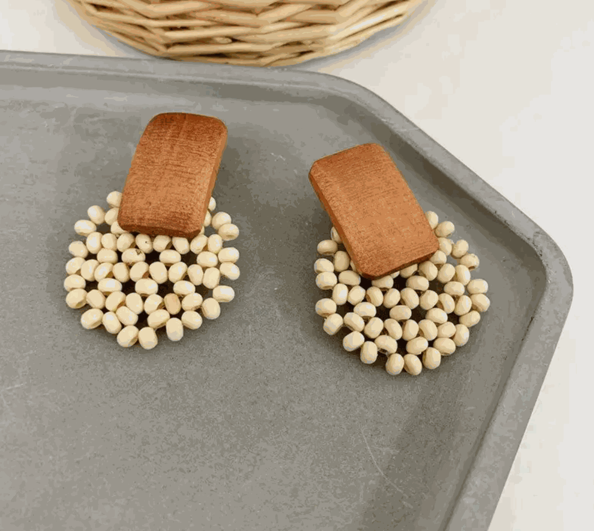 Terra Bloom wooden bead earrings with rectangular wood and cream-toned beads on a decorative tray.