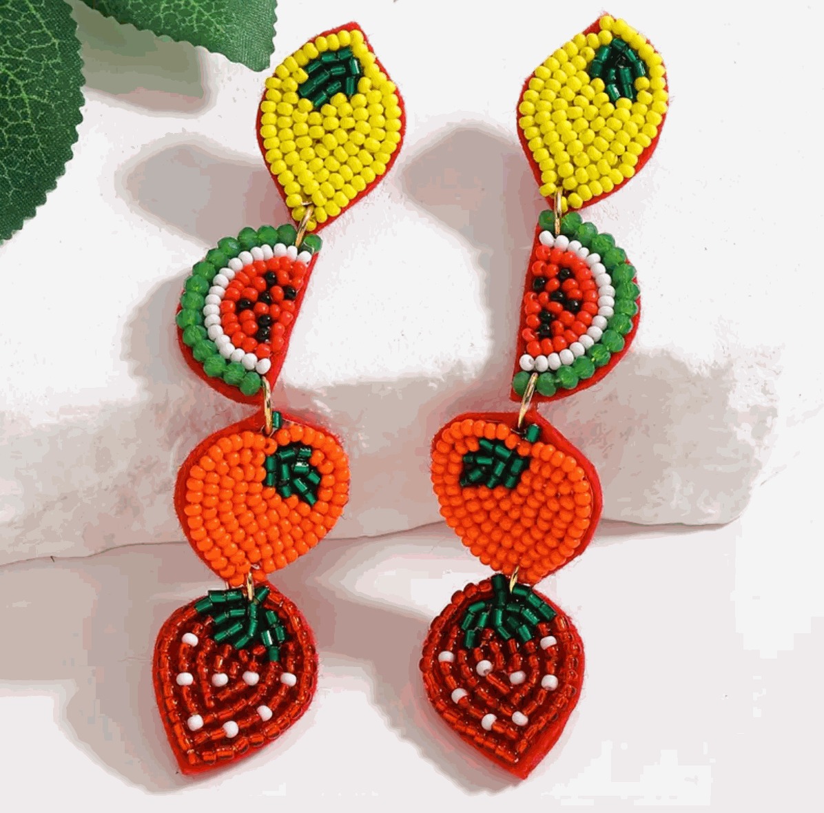 Colorful hand-beaded fruit earrings featuring lemon, watermelon, orange, and strawberry designs for a playful summer look.